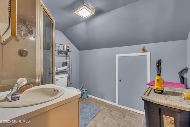 bathroom featuring lofted ceiling, vanity, baseboards, and walk in shower