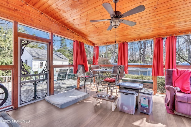 sunroom / solarium featuring vaulted ceiling, wood ceiling, and a ceiling fan