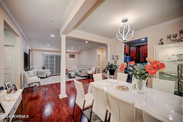 dining room featuring ornate columns, crown molding, a chandelier, and dark hardwood / wood-style flooring