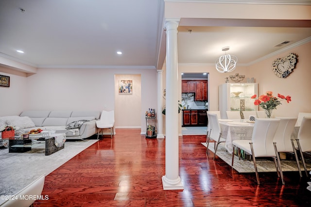 dining space with ornate columns, ornamental molding, dark wood-type flooring, and an inviting chandelier