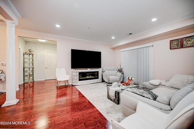 living room with decorative columns, wood-type flooring, and ornamental molding