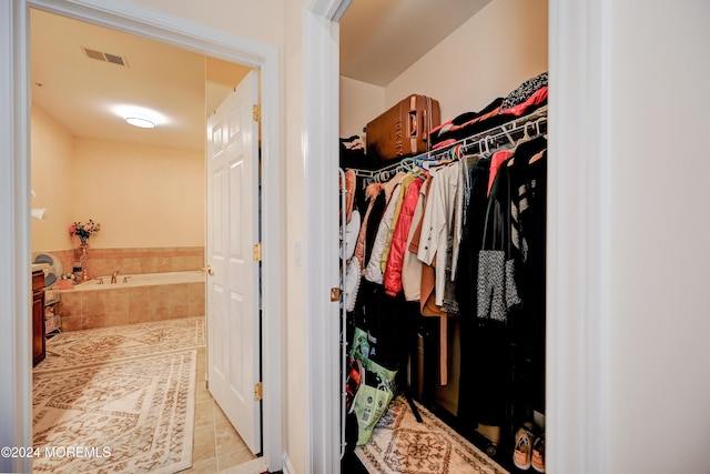 walk in closet with light tile patterned floors