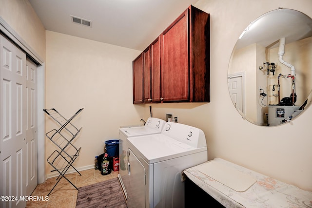 laundry room with independent washer and dryer, light tile patterned floors, and cabinets