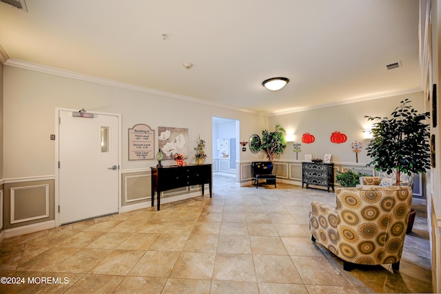 sitting room with ornamental molding and light tile patterned floors