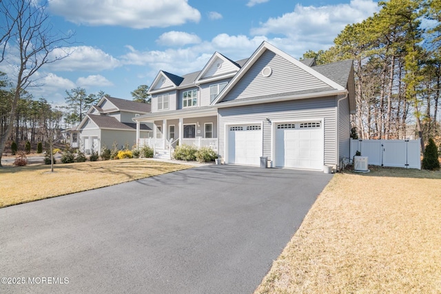 view of front facade featuring a porch, an attached garage, a gate, driveway, and a front lawn