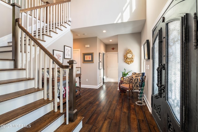 foyer entrance featuring recessed lighting, a towering ceiling, baseboards, stairway, and hardwood / wood-style floors