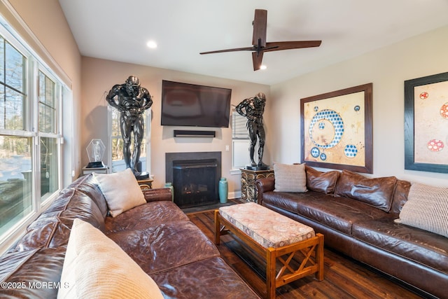 living area with a fireplace with flush hearth, recessed lighting, a ceiling fan, and wood finished floors