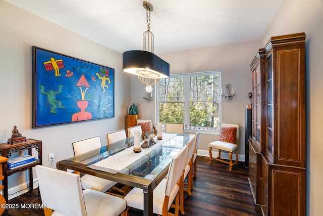 dining space featuring dark wood-style floors and baseboards