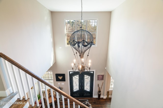 foyer with a notable chandelier, baseboards, french doors, stairway, and dark wood-style floors