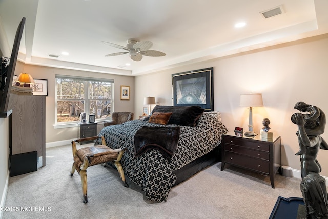 bedroom featuring a tray ceiling, carpet, visible vents, and baseboards