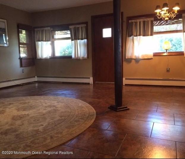 interior space featuring a baseboard heating unit and a notable chandelier