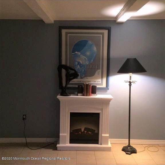 interior details with a fireplace, baseboards, and beamed ceiling