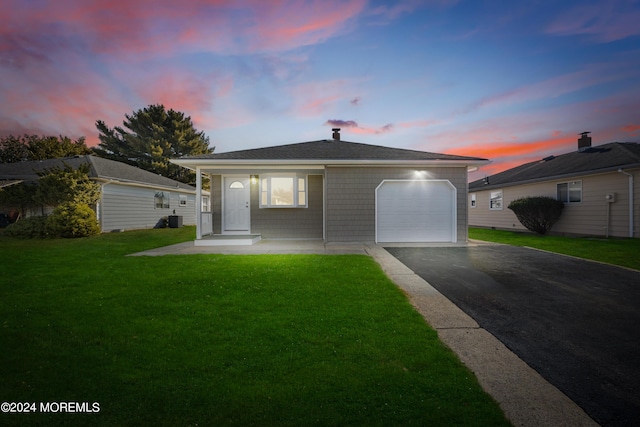 ranch-style house with a garage, a porch, central air condition unit, and a lawn