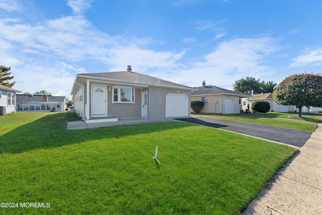 ranch-style home featuring a garage, a front lawn, and central air condition unit