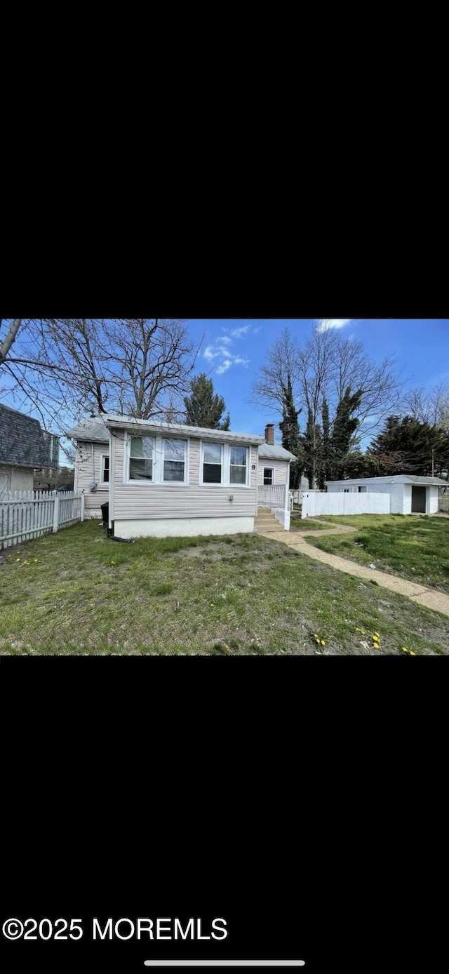 rear view of property with a lawn