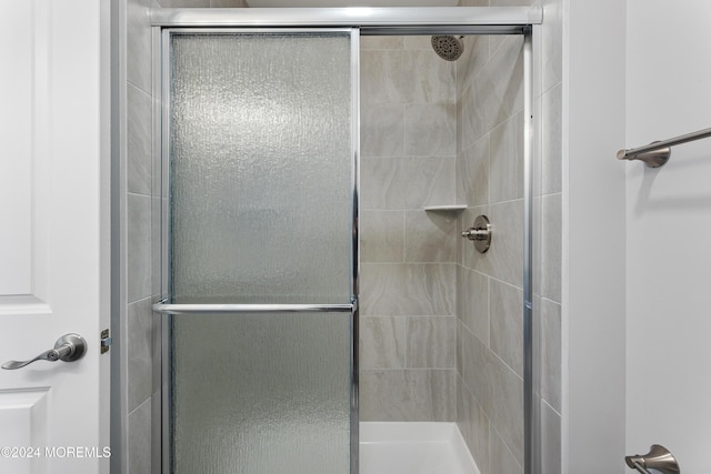 bathroom with a shower with door