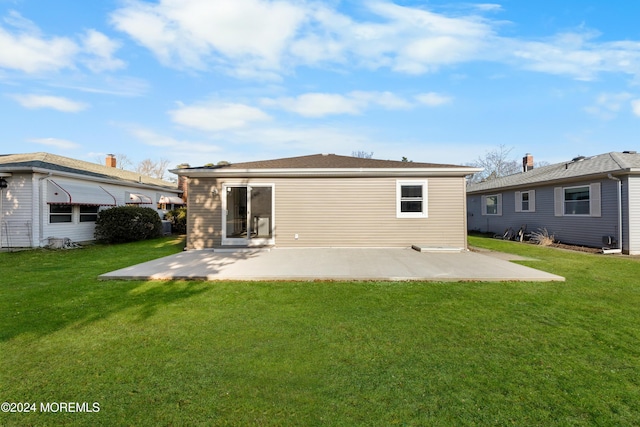 rear view of house featuring a lawn and a patio area