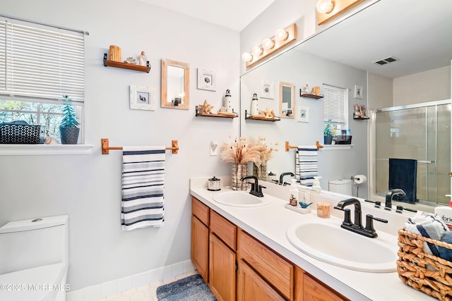 bathroom with vanity, tile patterned flooring, toilet, and walk in shower