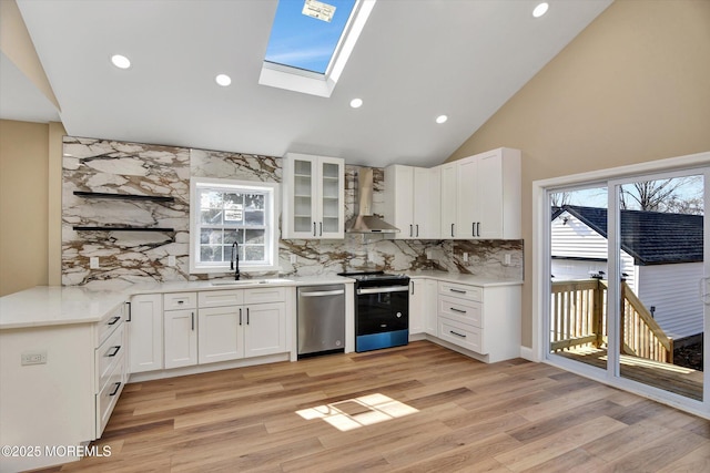 kitchen featuring electric stove, wall chimney exhaust hood, dishwasher, white cabinets, and sink