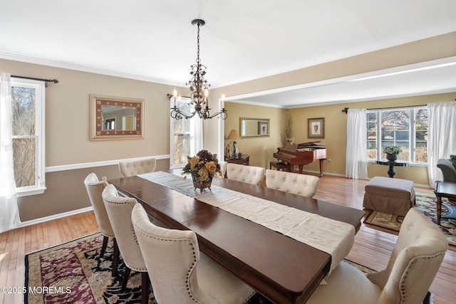 dining room with hardwood / wood-style flooring, crown molding, and a notable chandelier