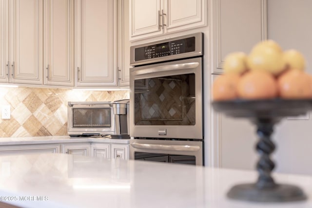 kitchen featuring double oven and tasteful backsplash