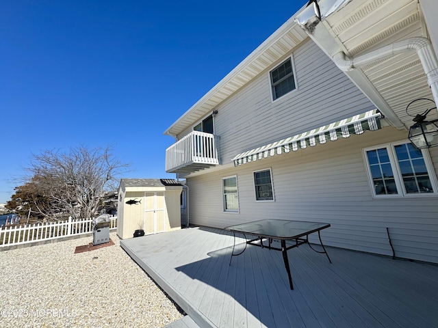 back of house with a balcony, a storage shed, and a deck