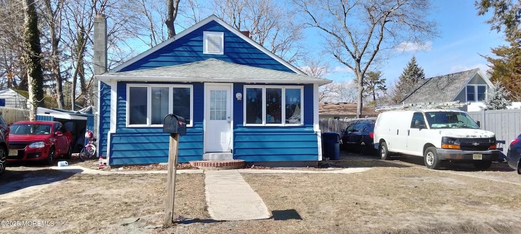 bungalow featuring fence