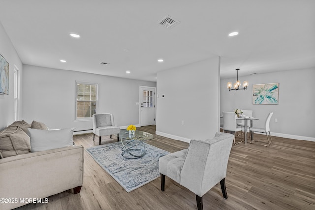 living area with baseboards, wood finished floors, and recessed lighting