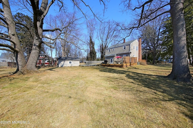 view of yard featuring a shed, an outdoor structure, and a wooden deck