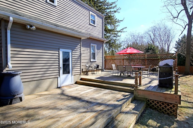 deck with outdoor dining space, grilling area, and fence