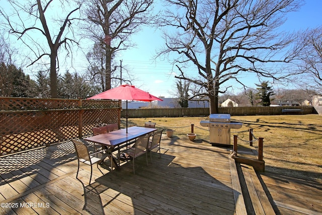 deck with outdoor dining area, area for grilling, and fence