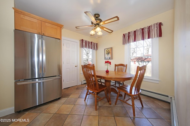 dining space with ceiling fan, a baseboard radiator, plenty of natural light, and light tile patterned flooring