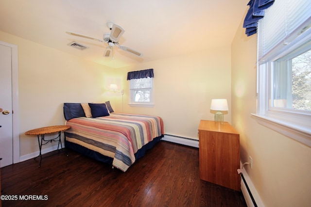 bedroom featuring a baseboard radiator, multiple windows, visible vents, and wood finished floors