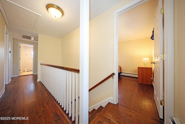 hallway with a baseboard radiator, visible vents, a baseboard heating unit, an upstairs landing, and hardwood / wood-style floors