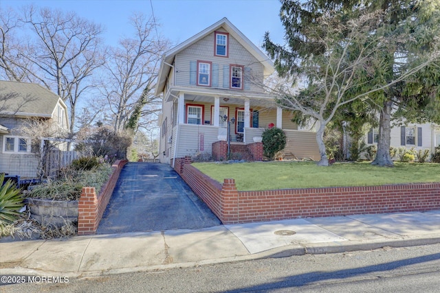 view of front of house with a front yard and covered porch