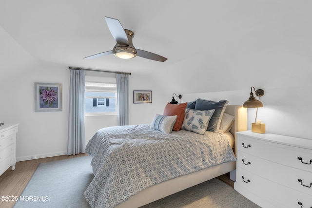 bedroom with hardwood / wood-style flooring, vaulted ceiling, and ceiling fan