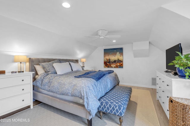 bedroom with ceiling fan, light wood-type flooring, and vaulted ceiling