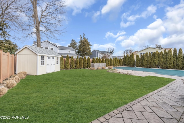 view of yard with a covered pool and a shed