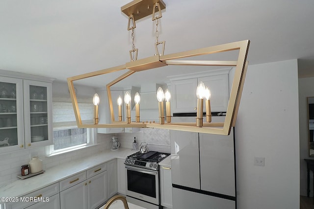 kitchen featuring white cabinets, gas range, and tasteful backsplash