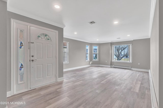 foyer entrance featuring a baseboard radiator, ornamental molding, and light hardwood / wood-style floors