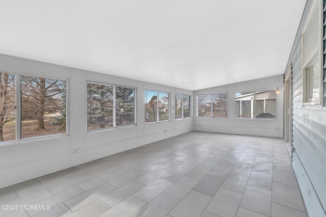 unfurnished sunroom featuring vaulted ceiling