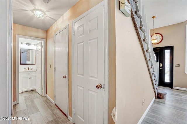 hallway with sink and light wood-type flooring