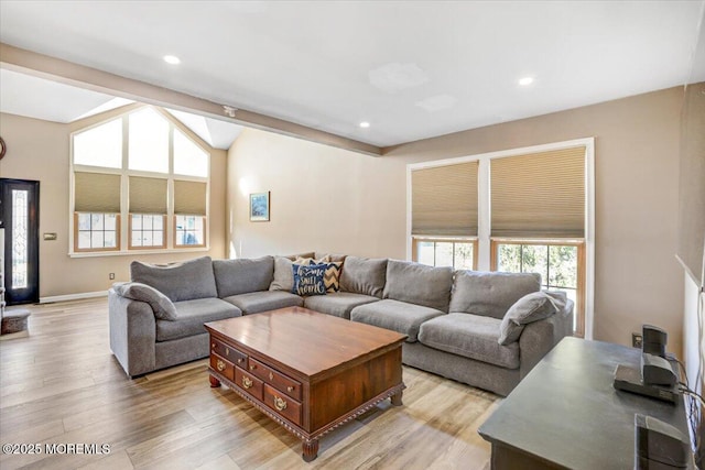 living room featuring vaulted ceiling with beams and light wood-type flooring