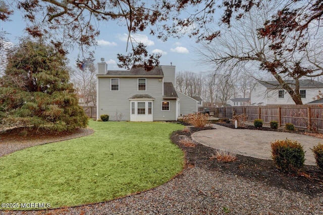 rear view of property featuring a lawn and a patio