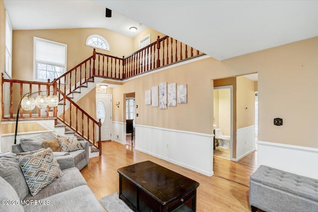 living room featuring high vaulted ceiling and light hardwood / wood-style floors