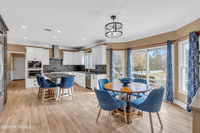 dining room with ornamental molding, recessed lighting, visible vents, and light wood-style flooring