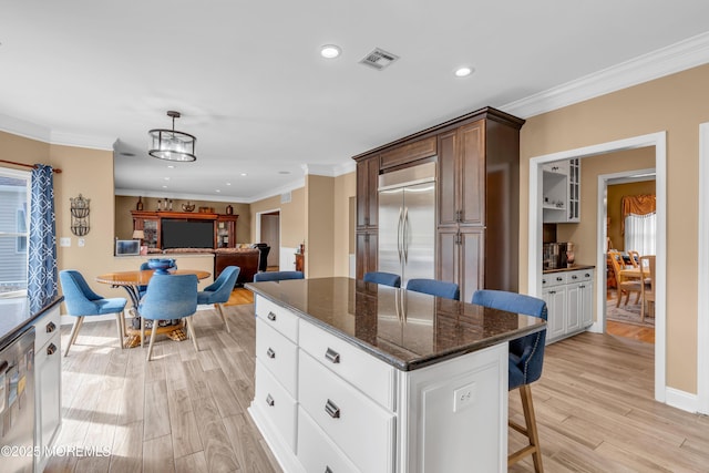 kitchen featuring a breakfast bar area, visible vents, white cabinets, hanging light fixtures, and appliances with stainless steel finishes