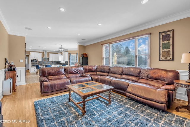 living area with recessed lighting, a wainscoted wall, crown molding, and light wood finished floors