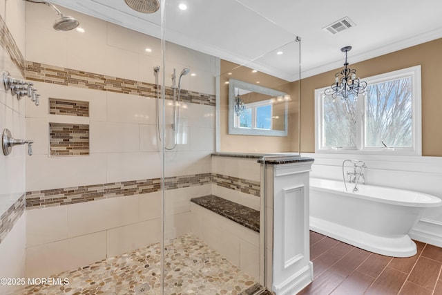 bathroom with visible vents, crown molding, a freestanding tub, a shower stall, and a wealth of natural light