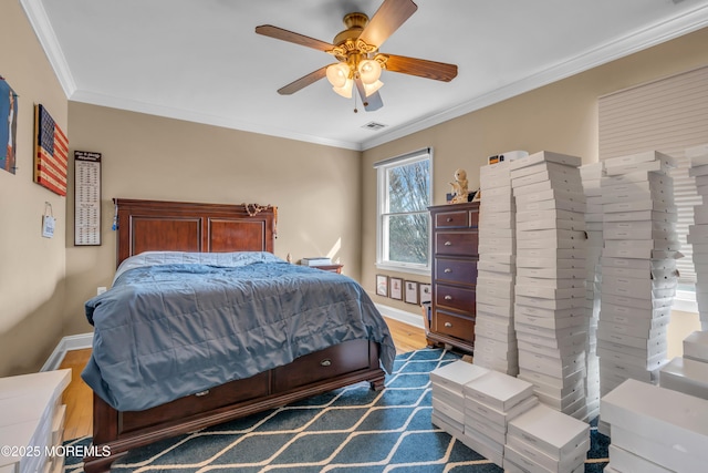 bedroom with dark wood finished floors, crown molding, visible vents, ceiling fan, and baseboards